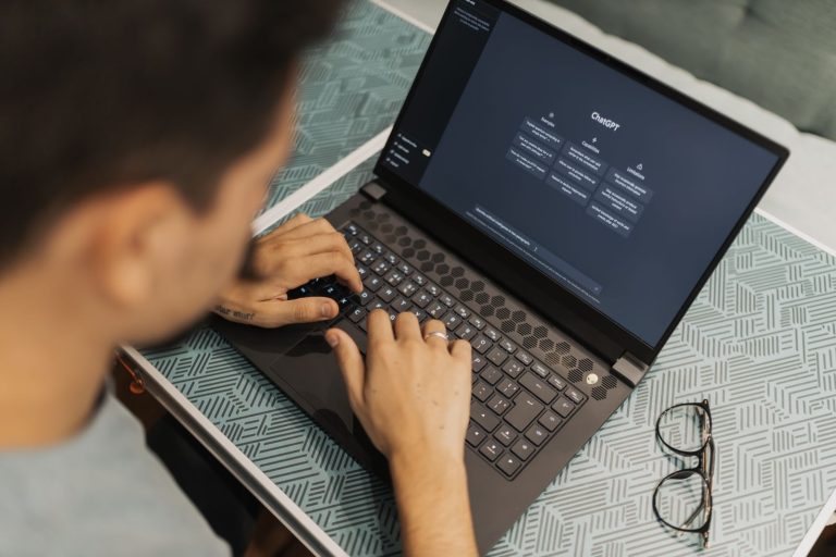 Person typing on a laptop with an AI chat assistant interface open on screen