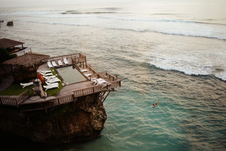 Aerial view of a clifftop villa pool and deck overlooking the ocean in Bali