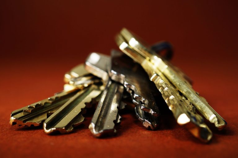 A bunch of brass keys on a dark red background