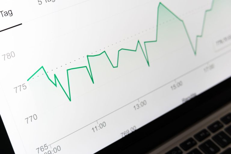 Laptop screen showing a green line chart of performance data